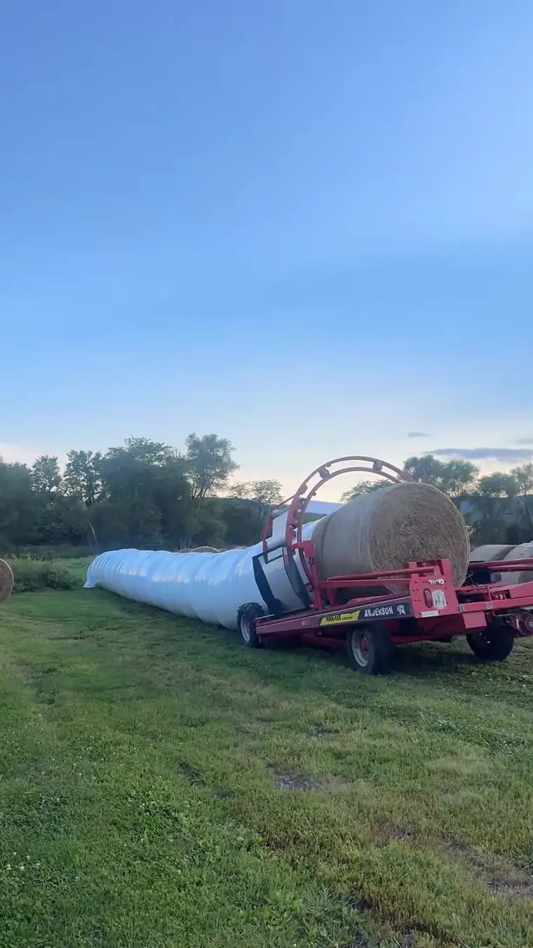 Anderson inline bale wrapper wrapping round bales in a field in Cumberland County, PA